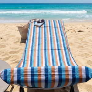 BeachSupplies.co.uk Sun Lounger Towel in use on a pool lounger — recycled rPET, 75 x 210cm with headrest pocket and storage pockets