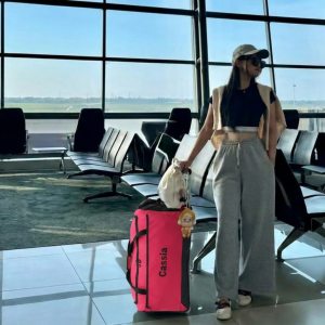 Woman travelling through airport with the Cassia 200 trolley duffle wheeled bag
